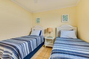 two beds sitting next to each other in a bedroom at Cute Cocoa Beach Condo w/ Pool & Beach Access! in Cocoa Beach +17 photos
