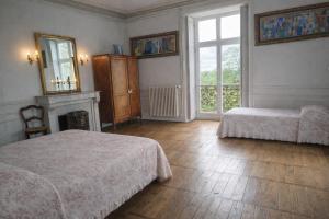 a bedroom with two beds and a fireplace and a window at L'intemporel, gîte de charme pour 4 à 5 personnes in Saint-Gervais-la-Forêt +17 photos