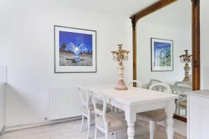 a white dining room with a white table and chairs at Designer Cottage with Parking - Esher Surrey - Pass the Keys in Esher