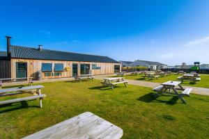 a group of picnic tables in the grass in front of a building at B17 SilverSands Escape in Lossiemouth