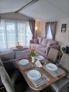 a living room with a table and a couch at B17 SilverSands Escape in Lossiemouth