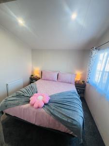 a bedroom with a large bed with a pink flower on it at B17 SilverSands Escape in Lossiemouth +14 photos