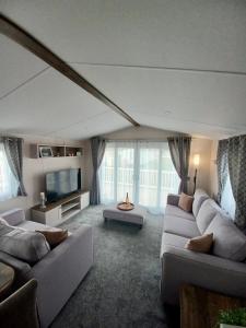 a living room with two couches and a tv at B17 SilverSands Escape in Lossiemouth