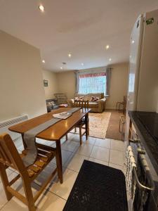 a kitchen and living room with a wooden table at The Cozy Covert in Spondon, Derby in Derby +7 photos