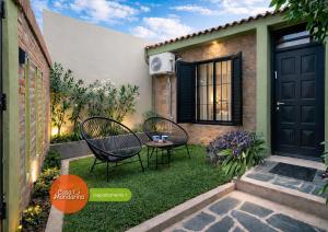 a small yard with two chairs and a door at Casa Mandarina San Luis in La Punta