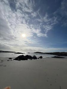 a beach with rocks in the sand under a cloudy sky at Atlantic beach house in Dog Island +21 photos