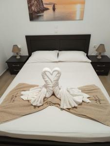 two towels in the shape of a heart on a bed at Apartments Kalaitzakis with private pool in Sitia +56 photos
