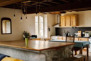 a kitchen with a large wooden counter top at La buanderie du château in Le Boulay +16 photos