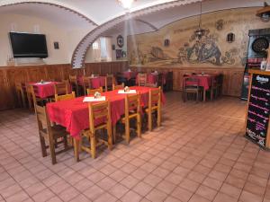 a dining room with tables and chairs and a tv at Penzion U Zeleného Stromu in Telnice
