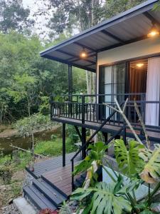 a house with a deck in the woods at Ingphai Homestay in Suratthani