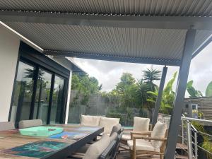 an outdoor patio with a table and chairs at Villa chandelle in Saint-Pierre