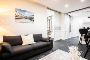 a living room with a couch and a bridge painting on the wall at Flandres Appart' Hotel - Schepers in Lille