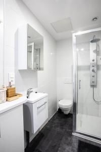 a white bathroom with a toilet and a shower at Flandres Appart' Hotel - Schepers in Lille +17 photos