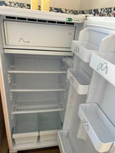 an empty refrigerator with its door open and empty shelves at Cozy Sousse Studio in Hammam Sousse