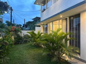 a house with palm trees in front of it at Luvi’s Villa in Galle