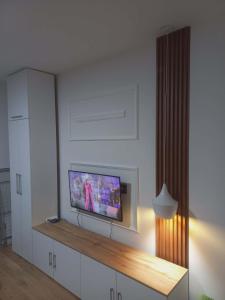 a living room with a flat screen tv on a wall at Apartman Symbol in Tuzla
