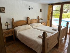 a bedroom with two beds and a window at Casa Olivo in Casarabonela