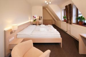 a hotel room with a bed and a chair at Wellness hotel Sauna in Malá Morávka