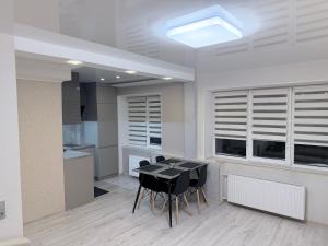 a kitchen with a black table and black chairs at G2 Apartments in Rēzekne