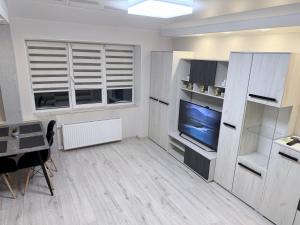 a living room with a television and a dining room at G2 Apartments in Rēzekne