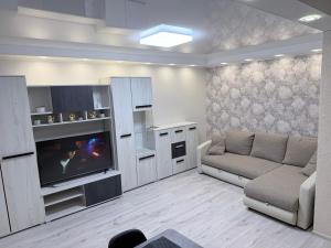 a living room with a couch and a flat screen tv at G2 Apartments in Rēzekne