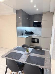 a kitchen with a dining table and chairs at G2 Apartments in Rēzekne