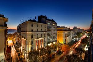 a city street at night with buildings and street lights at Colors Urban Hotel Thessaloniki in Thessaloniki
