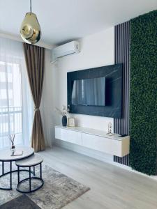 a living room with a large tv on a wall at Adam Residence in Oradea