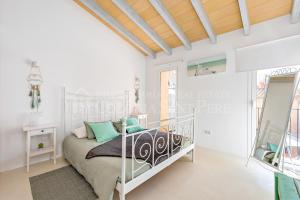 a white bedroom with a bed and a mirror at CAN REGALAT - Casa amb piscina a Artà in Artá +16 photos