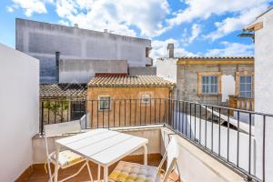 a balcony with a white table and chairs at CAN REGALAT - Casa amb piscina a Artà in Artá