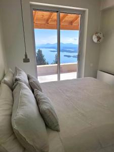 a bedroom with a large bed with a large window at Villa Kalivista in Spartýlas +19 photos