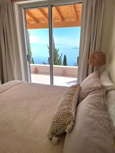a bedroom with a bed with a large window at Villa Kalivista in Spartýlas