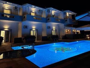 a large pool in front of a building at night at Harma Corfu in Sidari