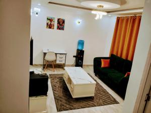 a living room with a green couch and orange curtains at Open Haven One Bedroom Apartments in Ongata Rongai 