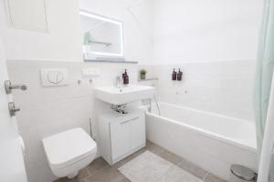 a white bathroom with a sink and a toilet at Larooms Merseburg - Apartment CS01 - 3 Zimmer, 7 Betten, 2 Bäder, 2 Parkplätze, Balkon & Aufzug in Merseburg +13 photos