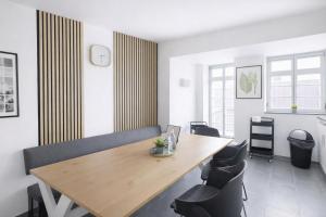 a dining room with a wooden table and chairs at Larooms Merseburg - Apartment CS01 - 3 Zimmer, 7 Betten, 2 Bäder, 2 Parkplätze, Balkon & Aufzug in Merseburg