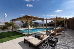 a patio with a pool and a table and chairs at הבית על ההר - Ella Sun in Eilat