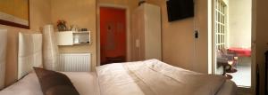 um quarto com uma cama branca e uma porta vermelha em Ferienwohnung Grimmer em Weil am Rhein