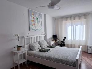 a white bedroom with a bed and a window at Apartamento Tibi - centro de Gandia in Gandía