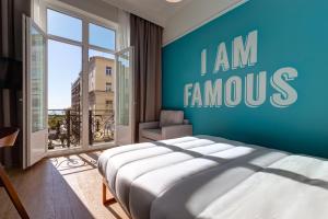 een slaapkamer met een groot bed met een blauwe muur bij Colors Urban Hotel Thessaloniki in Thessaloniki