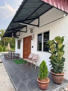 a patio with a black umbrella and a table and chairs at Rooma Bali Jeram in Kuala Selangor