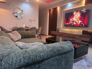 a living room with a couch and a tv on a wall at Chez Charly in Kinshasa