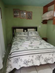 a bedroom with a large bed with white and gray sheets at Casa de Vivendas in Domingos Martins