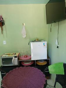 a kitchen with a microwave and a small refrigerator at Casa de Vivendas in Domingos Martins