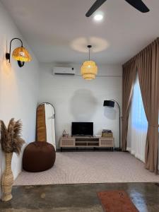 a living room with a television and a couch at Rooma Bali Jeram in Kuala Selangor