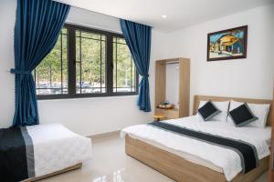 a bedroom with two beds and a window at Khách Sạn The Sum in Tây Ninh
