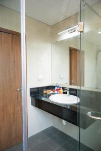 a bathroom with a sink and a glass shower at Khách Sạn The Sum in Tây Ninh