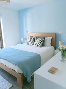 a bedroom with a bed with a blue blanket and pillows at Quinta da Casa Matilde - NATURE HOUSE in Geres