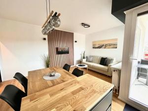 a kitchen and living room with a wooden table and a couch at Terrassenhaus, FeWo 45 in Duhnen