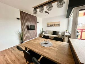 a dining room and living room with a wooden table and chairs at Terrassenhaus, FeWo 45 in Duhnen